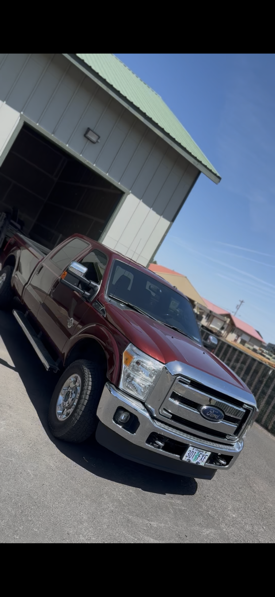 Maroon Ford F-250 Super Duty crew cab freshly tinted outside the Sisters, Oregon shop